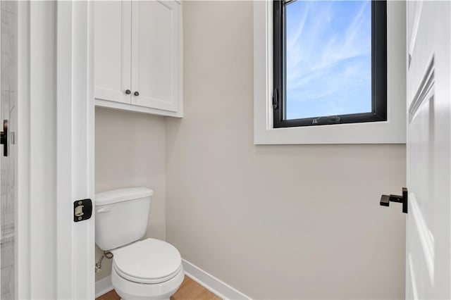 bathroom with baseboards and toilet