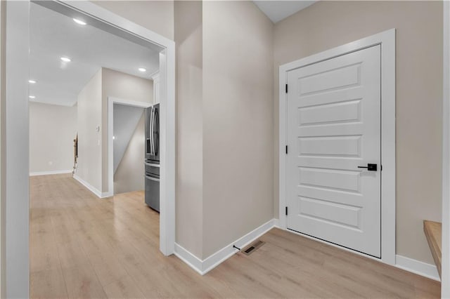 entryway with light wood finished floors, baseboards, visible vents, and recessed lighting