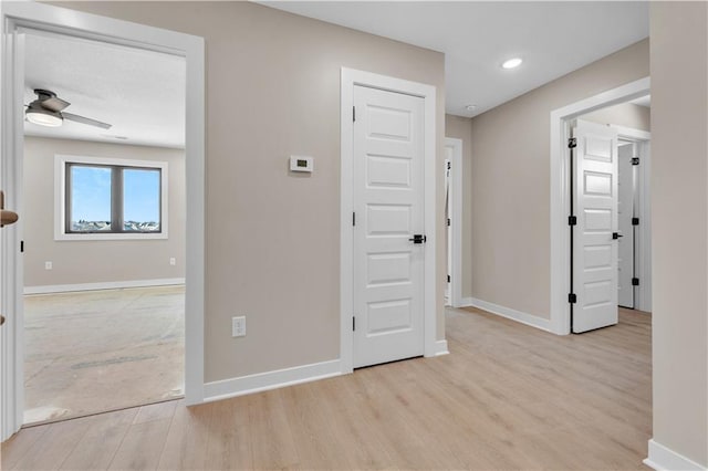 hall with baseboards, recessed lighting, and light wood-style floors