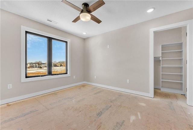 unfurnished bedroom featuring ceiling fan, recessed lighting, visible vents, baseboards, and a walk in closet