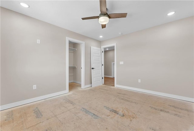 unfurnished bedroom featuring a ceiling fan, a walk in closet, baseboards, and recessed lighting