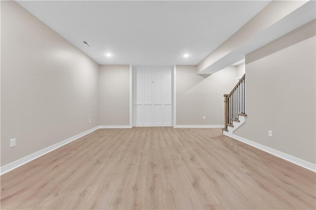 finished basement with baseboards, visible vents, stairway, light wood-type flooring, and recessed lighting