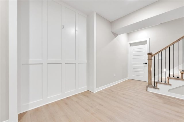 interior space featuring stairs, baseboards, and light wood-style floors