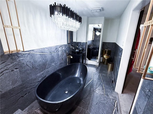 full bath featuring marble finish floor, a wainscoted wall, tile walls, visible vents, and vanity