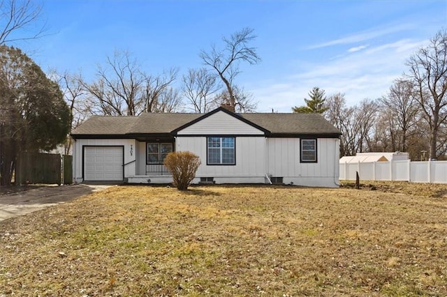 view of front facade featuring a garage, driveway, fence, and a front yard