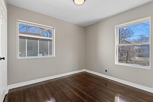 spare room featuring baseboards and hardwood / wood-style floors