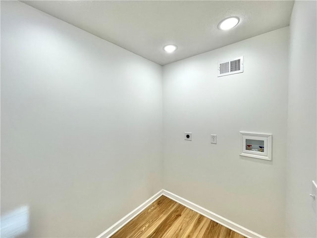 washroom featuring hookup for a washing machine, wood finished floors, visible vents, baseboards, and electric dryer hookup