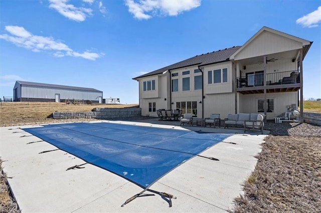 view of swimming pool featuring an outdoor living space, a patio area, a ceiling fan, and a fenced in pool