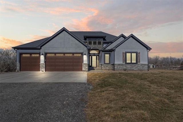 view of front of home with stone siding, concrete driveway, a front lawn, and an attached garage