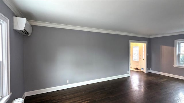 empty room featuring dark wood-type flooring, a wall mounted air conditioner, ornamental molding, and baseboards