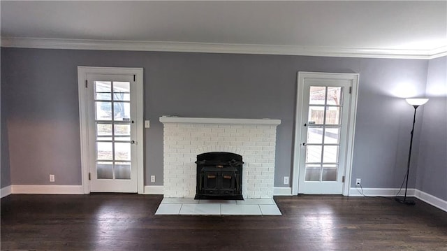 unfurnished living room with ornamental molding, wood finished floors, and baseboards