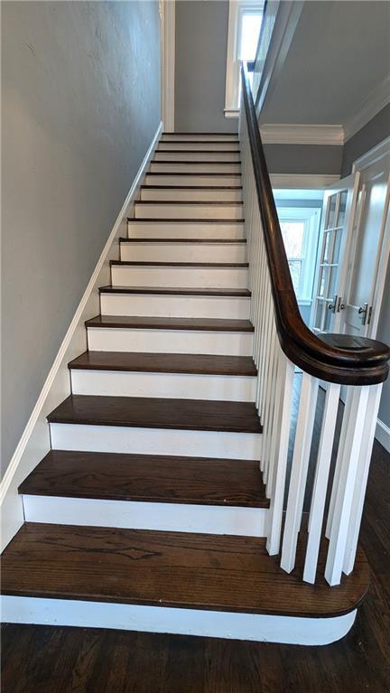 stairs with ornamental molding and wood finished floors