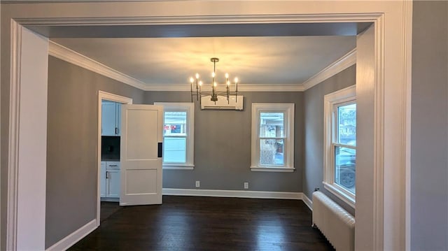 unfurnished dining area featuring radiator heating unit, ornamental molding, dark wood-style flooring, and a wall mounted air conditioner