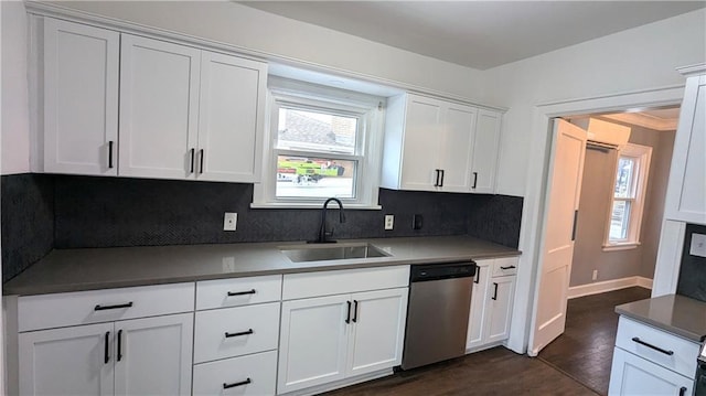 kitchen featuring tasteful backsplash, white cabinets, dishwasher, dark wood-style flooring, and a sink