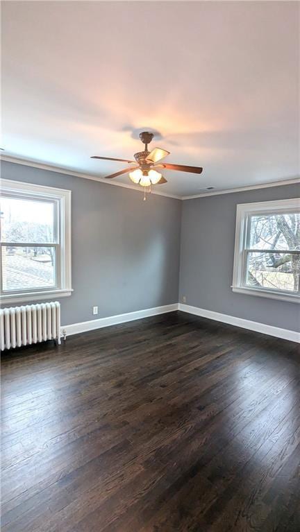 empty room featuring radiator, baseboards, dark wood-style flooring, and crown molding