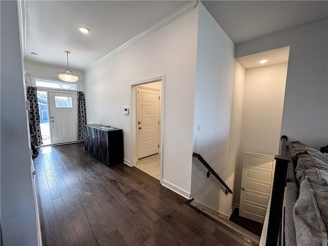 foyer featuring crown molding, baseboards, and dark wood-style flooring