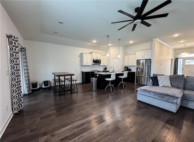 living room featuring dark wood-style flooring, recessed lighting, a ceiling fan, and baseboards