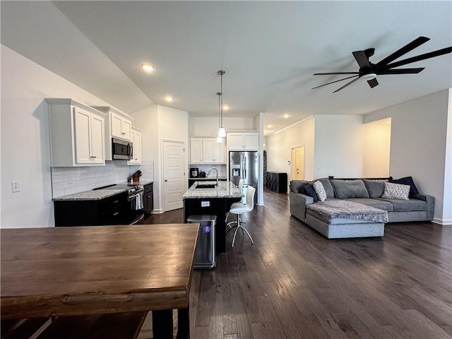 interior space with dark wood-style floors, lofted ceiling, ceiling fan, and recessed lighting