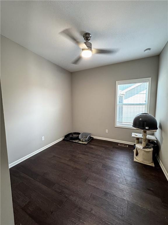 spare room featuring visible vents, a ceiling fan, a textured ceiling, wood finished floors, and baseboards