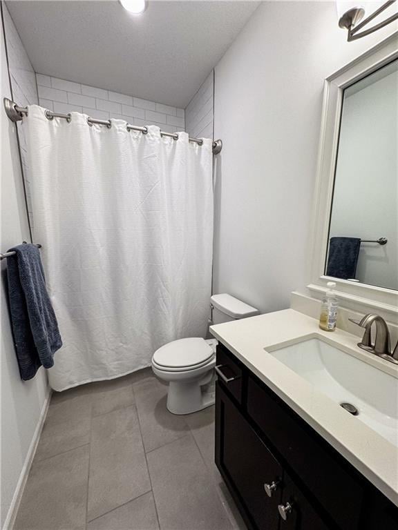 bathroom featuring a shower with shower curtain, vanity, toilet, and tile patterned floors