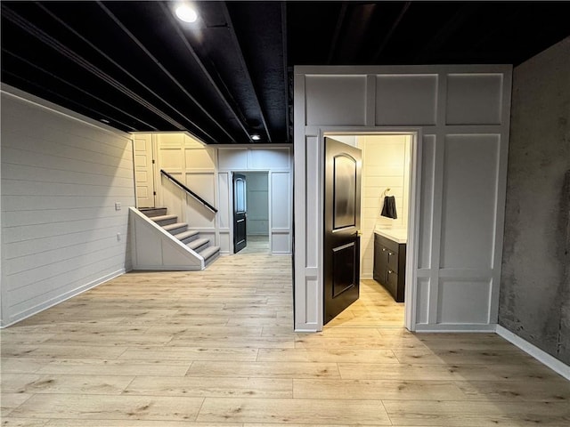 corridor with light wood finished floors and stairs