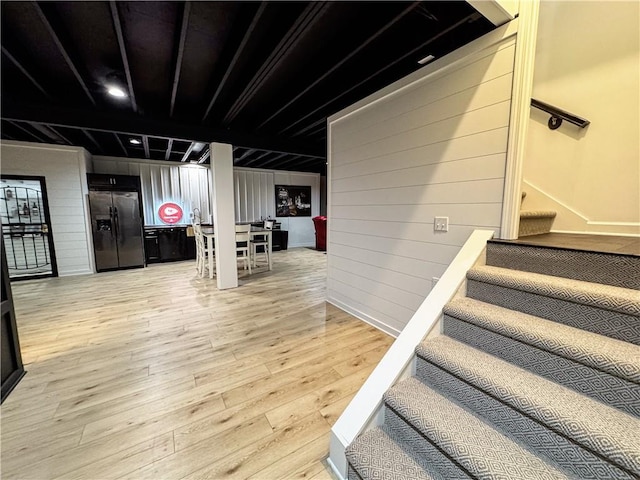 stairway featuring wooden walls and wood finished floors