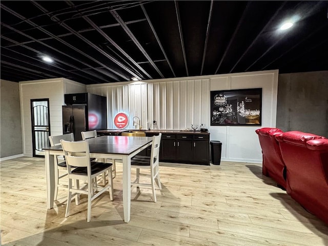 dining space featuring light wood finished floors and baseboards