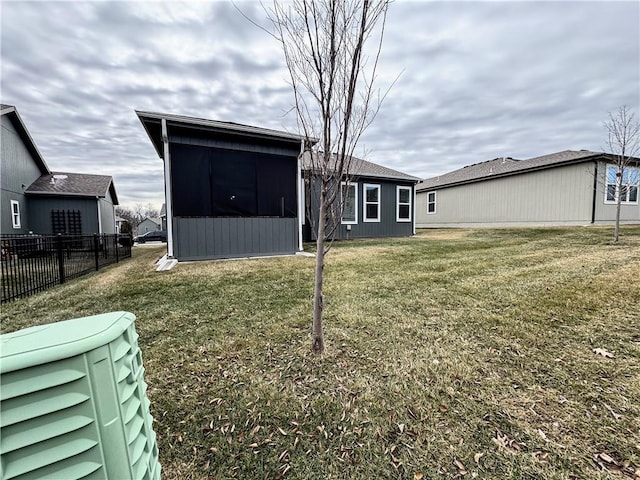 back of property featuring fence and a lawn