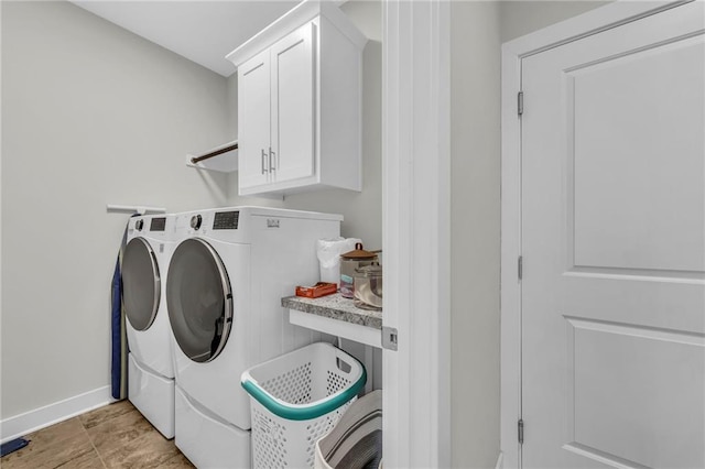 laundry area with cabinet space, baseboards, and washing machine and clothes dryer