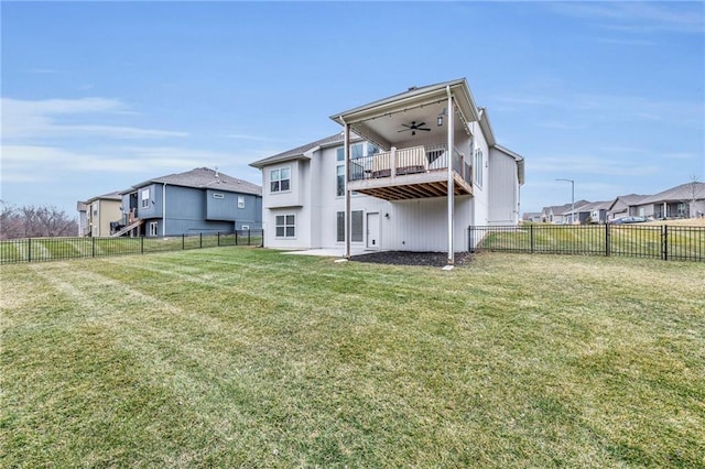 rear view of house with a yard, a fenced backyard, and ceiling fan