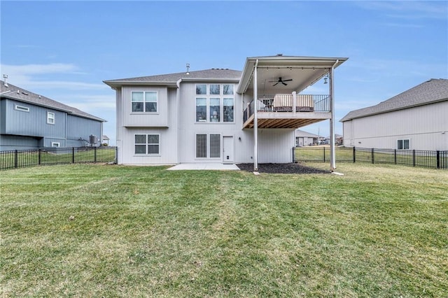 rear view of house with a fenced backyard, a yard, and ceiling fan