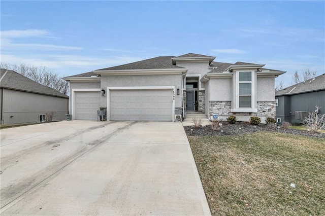 prairie-style house with stucco siding, concrete driveway, an attached garage, a front yard, and stone siding