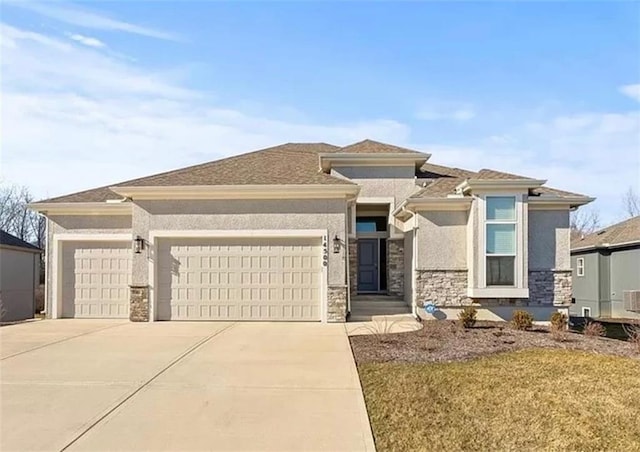 prairie-style home featuring a garage, stone siding, concrete driveway, and stucco siding