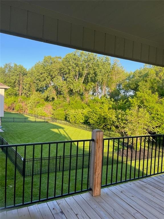 wooden deck with fence and a lawn