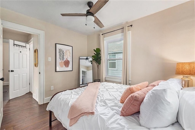 bedroom with dark wood-style floors, ceiling fan, and baseboards