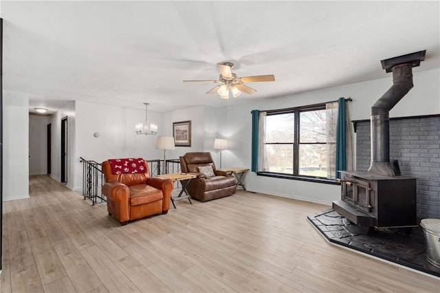 17259 174th St, Basehor, KS 66007 - living area featuring ceiling fan, light wood-style flooring, a wood stove, and baseboards