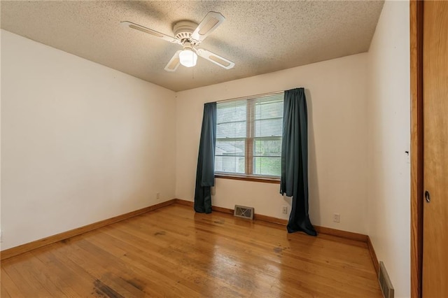 empty room featuring baseboards, visible vents, and light wood-style floors