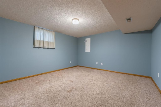 carpeted spare room featuring baseboards, visible vents, and a textured ceiling