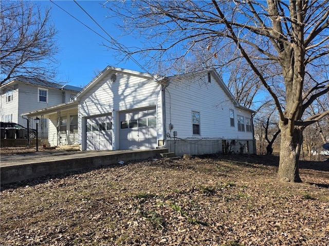 view of side of property with driveway and an attached garage