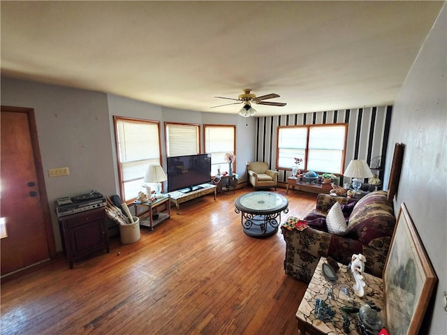 living area with a ceiling fan and hardwood / wood-style floors