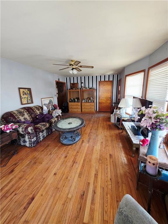 living area with a ceiling fan and hardwood / wood-style floors