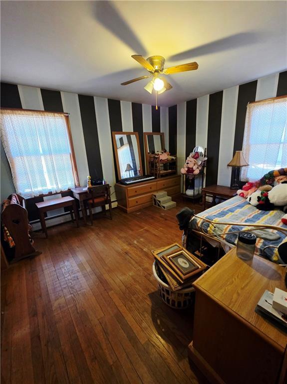 bedroom with hardwood / wood-style floors and wallpapered walls