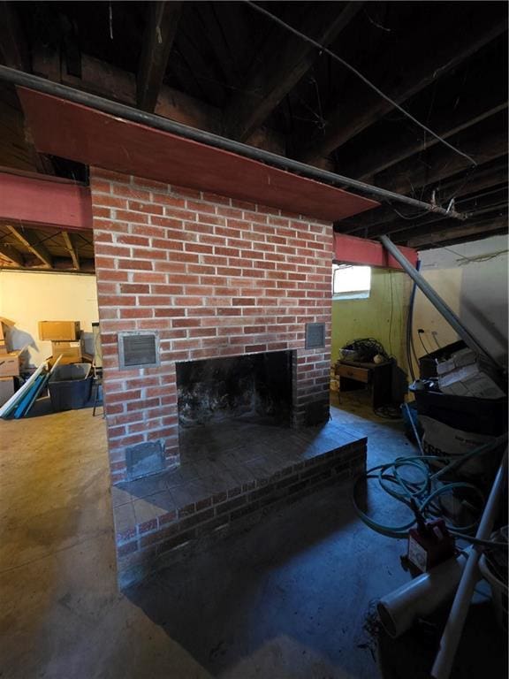 interior details featuring concrete floors, a brick fireplace, and visible vents