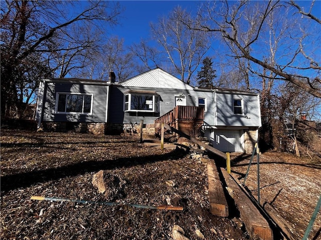 view of front of home with dirt driveway and an attached garage