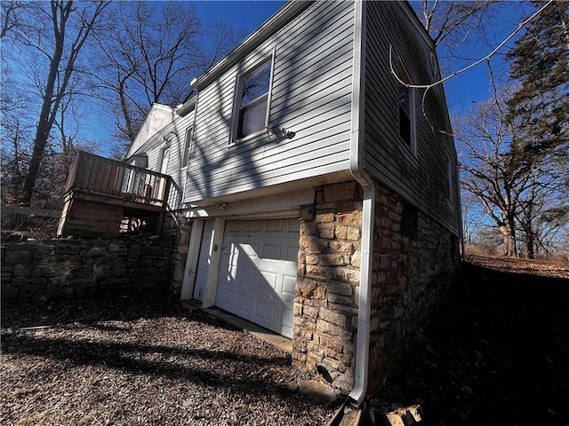 view of property exterior featuring a garage and stone siding