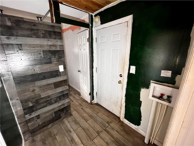 interior space featuring dark wood-type flooring and wood walls