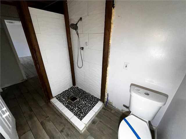 full bathroom with toilet, a stall shower, and wood finished floors