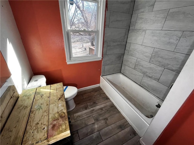 full bathroom featuring toilet, baseboards, wood finished floors, and shower / bathtub combination