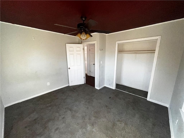 unfurnished bedroom with a closet, dark carpet, and baseboards