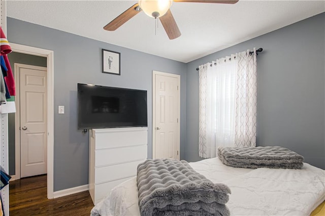 bedroom featuring ceiling fan, baseboards, and wood finished floors